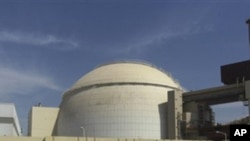 A worker rides a bike in front of the reactor building of the Bushehr nuclear power plant, just outside the southern city of Bushehr, Iran, 26 Oct 2010