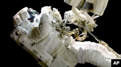 Imagen de video proporcionada por la NASA muestra al astronauta Joe Acaba durante la caminata espacial del 20 de octubre para reparar una cámara exterior de la Estación Espacial Internacional.