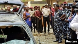 An eye witness of the bomb blast gives his account to the Kano commissioner of the police during the police chief's assessment of the situation in Sabon Gari, Kano, May 19, 2014.