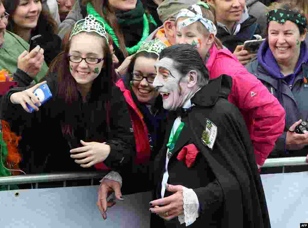 A man dressed as Dracula takes pictures with spectators as he takes part in the St Patrick's Day parade in Dublin, Ireland, on March 17, 2015.