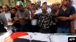 Người Palestine cầu nguyện trước thi thể của ông Saed Dawabsheh, tại tang lễ của ông ở làng Duma, 8/8/2015.