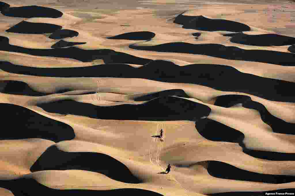 France&#39;s biker Adrien Van Beveren (R) powers his Yamaha in front Us&#39; biker Andrew Short during the Stage 11 of the Dakar 2022 around Bisha, Saudi Arabia.