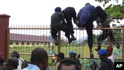 Papuanese who attended the Third Papuan People Congress climb a fence after police and troops dispersed the crowd at the event in Abepura in Indonesia's Papua province, October 19, 2011.