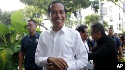 Incumbent Indonesian President Joko Widodo, center, smiles upon arriving for a meeting with leaders of his coalition parties in Jakarta, Indonesia, April 18, 2019.