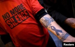 FILE - Paul Levely, a child sex abuse victim, wears a T-shirt that says "no more silence" and shows a tattoo on his arm in Rome, Italy, Feb. 28, 2016.