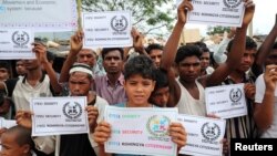 Người tị nạn Rohingya giơ biểu ngữ đòi các quyền cơ bản khi Tổng thư ký LHQ Antonio Guterres và Giám đốc Ngân hàng Thế giới Jim Yong Kim đến thăm trại Kutupalong ở Cox’s Bazar, Bangladesh, ngày 2/7/2018. 
