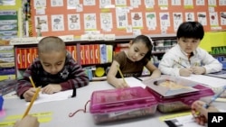 FILE - Kindergarten students work in a bilingual English-Spanish class at school in Texas. 