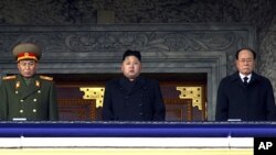 In this photo taken Thursday, Dec. 29, 2011, new North Korean leader Kim Jong Un, center, presides over a national memorial service for his late father Kim Jong Il at Kim Il Sung Square in Pyongyang, North Korea. Flanking him are Kim Yong Nam, president o