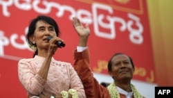 Burma's Aung San Suu Kyi, left, gives her speech beside a candidate for the National League for Democracy party in Yangon.