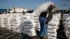 FILE - A man carries sacks of food aid for distribution to Internally displaced people (IDPs) in the POC (Protection of Civilians) Camp, run by the UN Mission in South Sudan near the town of Malakal, in the Upper Nile state of South Sudan.