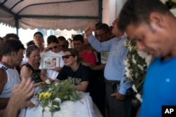 Carla Cristina Santos grieves over the coffin holding her 22-year-old son Matheus Lessa in Rio de Janeiro, Brazil, Jan. 17, 2019. Lessa was shot and killed while trying to protect his mother during a robbery in their family-owned store.