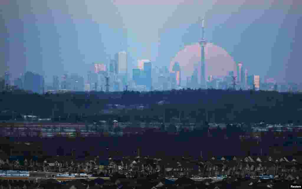 The moon rises over the Toronto city skyline as seen from Milton, Ontario, Canada, Jan. 23, 2016.