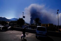 Un hombre lleva comestibles de un supermercado mientras un volcán continúa en erupción en El Paso, en la isla canaria de La Palma, España, el sábado 9 de octubre de 2021.