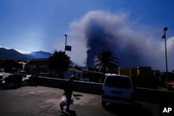 Un hombre lleva comestibles de un supermercado mientras un volcán continúa en erupción en El Paso, en la isla canaria de La Palma, España, el sábado 9 de octubre de 2021.