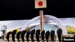 Участники национальной поминальной службы в день 10-й годовщины катастрофы в Токио, Япония, 11 марта 2021 г