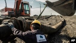 Рабочие «Норникеля» разбирают трубопровод, из которого происходит утечка в местную реку (архивное фото)
