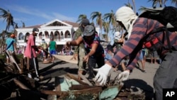 Typhoon survivors and volunteers begin a massive clean up in Tacloban city.