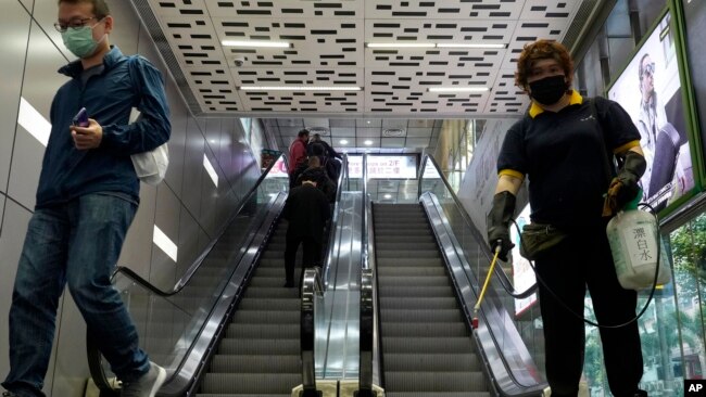 一名戴着口罩的香港工作人员正在喷洒消毒剂。（2020年3月17日）