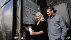 The Skysource/Skywater Alliance co-founders David Hertz, right, and his wife Laura Doss-Hertz demonstrate how the Skywater 300 turns air into water, in Los Angeles, Oct. 24, 2018. 