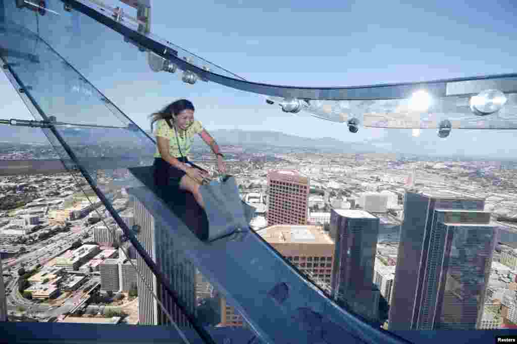 Sandra Brown rides the Skyslide on the 69th and 70th floors of the U.S. Bank Tower which is attached to the OUE Skyspace LA observation deck in downtown Los Angeles, California, USA, June 20, 2016.