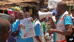 FILE - Health workers teach people about the Ebola virus and how to prevent infection in Conakry, Guinea, March 31, 2014. 