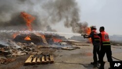 Bomberos palestinos intentan extinguir las llamas en una terminal de carga en Karni, entre Israel y Gaza, luego de ser bombardeada por tanques israelíes.