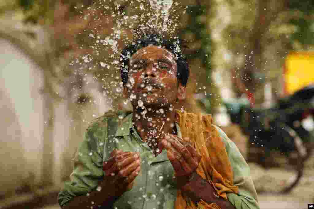 A worker splashes water to cool himself off on a hot summer afternoon in Prayagraj, Uttar Pradesh, India.