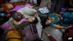 Một người đàn ông Ấn Độ khóc bên thi thể người vợ thiệt mạng trong vụ giẫm đạp tại nhà ga xe lửa ở Allahabad, ngày 10/2/2013.