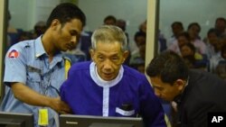 ဒွိုက် (Duch) ဟုခေါ်သော ခမာနီ ထောင်မှူးဟောင်းအား ကုလသမဂ္ဂ ကျောထောက် နောက်ခံ ပေးထားသော တရားရုံးတွင် တွေ့ရပုံ။