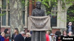 People attending the official unveiling gather around the statue of suffragist Millicent Fawcett on Parliament Square after the ceremony, in London, Britain, April 24, 2018.