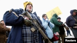 Un joven porta un fusil AR-15 en mitin a favor de las armas frente al Capitolio en Utah. Las regulaciones sobre armas son dispares entre la legislación federal y las estatales. Hechos de violencia con asesinatos múltiples reviven cada cierto tiempo el debate. (Foto VOA / Archivo)