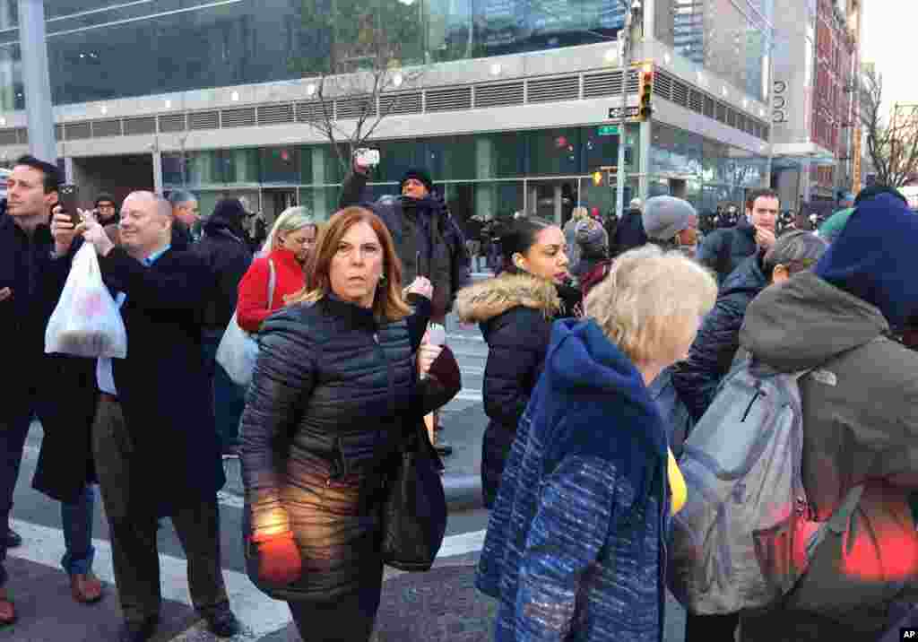 Para pengunjung berjalan melewati polisi yang menanggapi laporan mengenai ledakan di dekat Times Square, 11 Desember 2017, di New York.