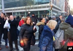 A crowd moves past police responding to a report of an explosion near Times Square on Dec. 11, 2017, in New York.