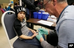 A nurse draws a blood sample from a student at Eisenhower Elementary School in Flint, Michigan, Jan. 26, 2016. Students at the school were being tested for lead after the metal was found in the city's drinking water.