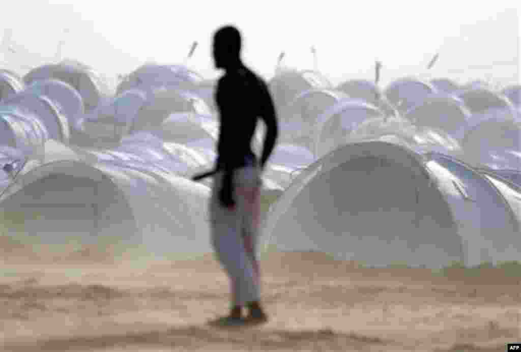 Displaced people play soccer backdropped by their refugee camp at the Tunisia-Libyan border. The camp houses about 5,000 people, trying to handle the large numbers of expatriates crossing the border into Tunisia. (AP/Lefteris Pitarakis)