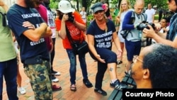 FILE - Shannon Martinez shows the Celtic cross tattoo on her leg to protesters at the “Unite the Right” rally in Washington, D.C., Aug. 12, 2018. (Photo courtesy of Shannon Martinez)