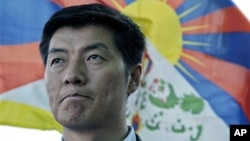 In this March 20, 2011 file photo, newly-elected Tibetan prime minister Lobsang Sangay talks to the Associated Press with a Tibetan flag in the background in Dharmsala, India.