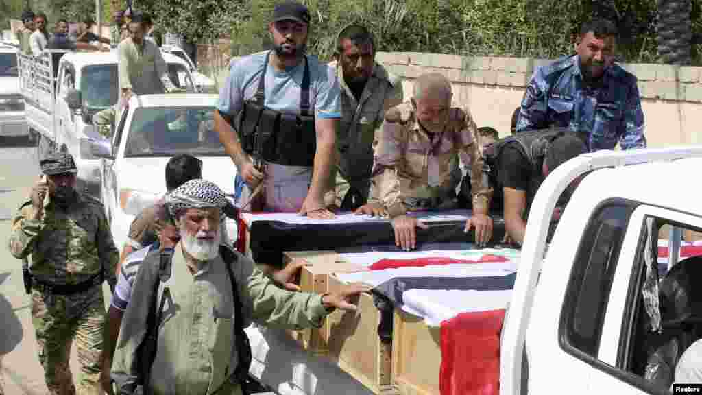 Mourners carry the coffins of Iraqi Shi'ite volunteers, who were killed during clashes with militants of the Islamic State, formerly known as the Islamic State of Iraq and the Levant (ISIL) in Amerli, during a funeral in Khalis, Iraq, Aug. 31, 2014. 