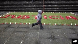 A child runs past an arrangement of flowers and candles that spells out "justicia" (justice) in front of the Supreme Court at Guatemala City in this August 2011 photo.