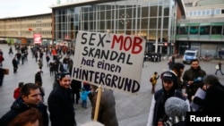 A person holds up a placard reading 'The sex mob scandal has a background' prior to a Patriotic Europeans Against the Islamisation of the West (PEGIDA) demonstration march in front of the main train station in Cologne, Germany, Jan. 9, 2016. 