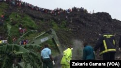 Des pompiers recherchent des corps ou d’éventuels survivants après l’éboulement d’une décharge publique dans la banlieue de la capitale, Conakry, 22 août 2017. (VOA/Zakaria Camara)