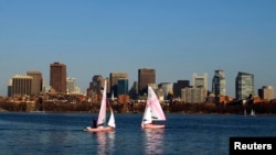 FILE - Collegiate sailors practice on the Charles River in front of the Boston skyline in Cambridge, Massachusetts, March 20, 2012. 