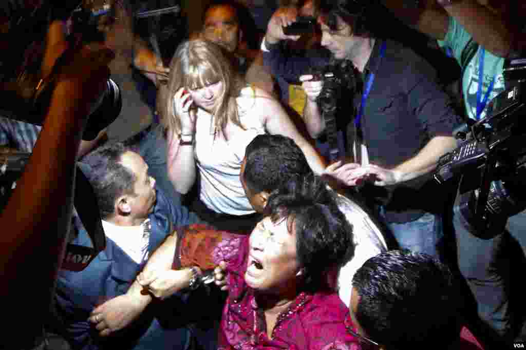 A Chinese family member of a passenger onboard missing Malaysia Airlines Flight MH370 screams as she is being brought into a room outside the media conference area at a hotel near Kuala Lumpur International Airport, March 19, 2014. 