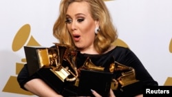 Singer Adele holds her six Grammy Awards at the 54th annual Grammy Awards in Los Angeles, California on Feb. 12, 2012.