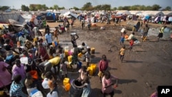 FILE - A year after fighting broke out in South Sudan, people gathered around a water truck to fill containers at a U.N. compound in Juba that had become home to thousands of displaced people, Dec. 29, 2013.