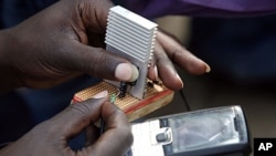 Jeremiah Murimi, a Kenyan electrical engineering student demonstrates how a "smart charger" connected to a bicycle can power a mobile phone (file photo).