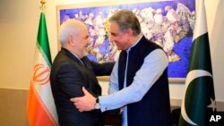 In this photo released by the Foreign Office, Pakistani Foreign Minister Shah Mehmood Qureshi, right, shakes hands with Iranian Foreign Minister Mohammad Javad Zarif at the Foreign Ministry in Islamabad, Pakistan, May 24, 2019. 
