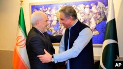 Menlu Iran Mohammad Javad Zarif (kiri) berjabat tangan dengan Menlu Pakistan Shah Mehmood Qureshi sebelum pertemuan di Islamabad, hari Jumat (24/5).