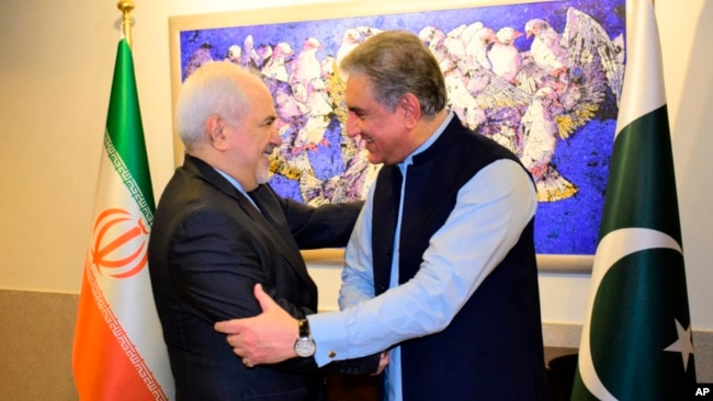 Menlu Iran Mohammad Javad Zarif (kiri) berjabat tangan dengan Menlu Pakistan Shah Mehmood Qureshi sebelum pertemuan di Islamabad, hari Jumat (24/5).