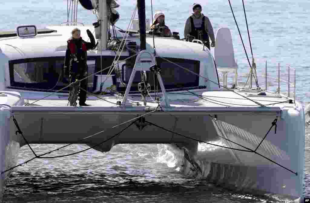 Climate activist Greta Thunberg waves as she arrives in Lisbon, Portugal, aboard the sailboat La Vagabonde.